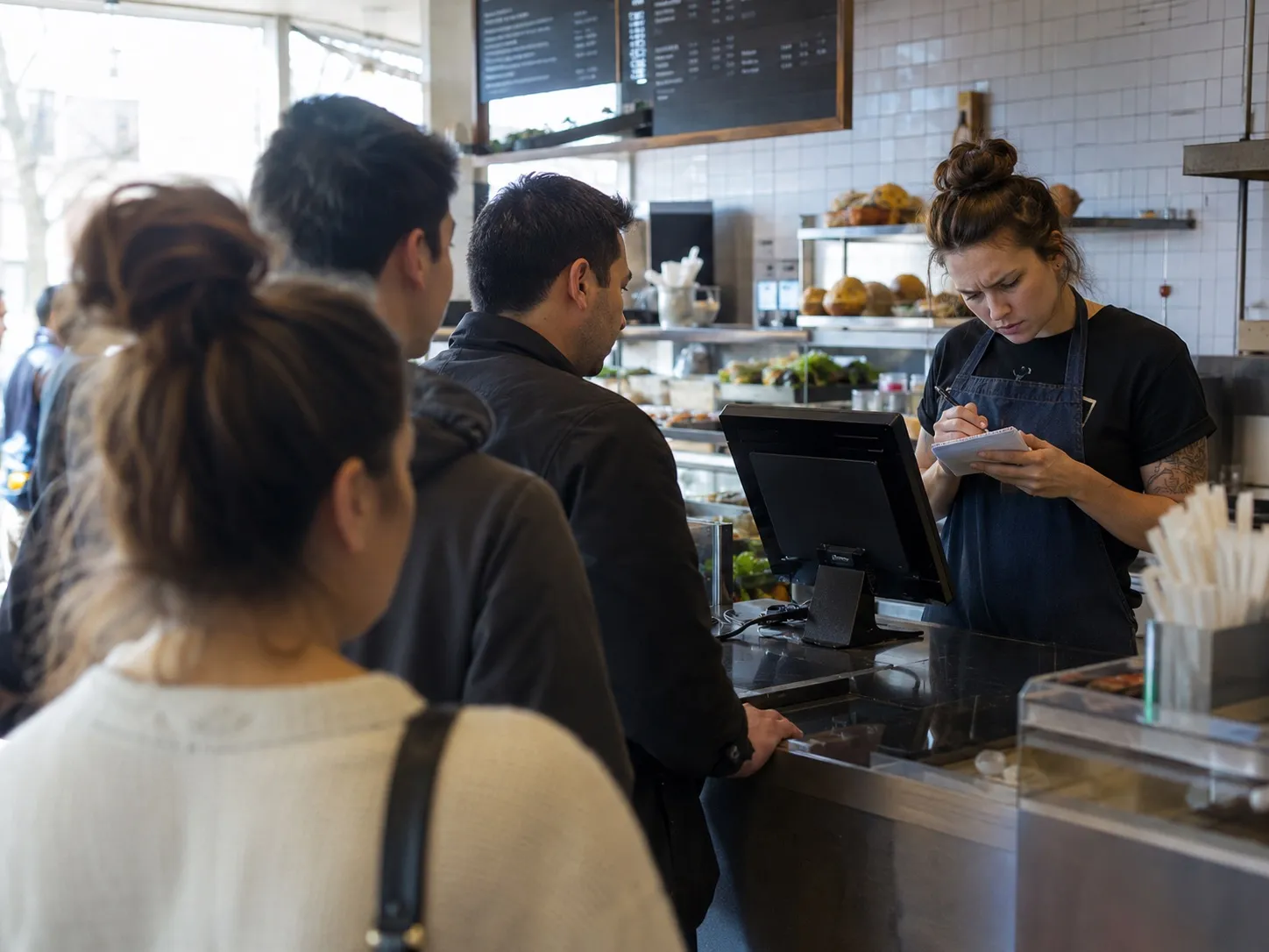 A quick-serve counter at peak lunch hour with a frozen POS.